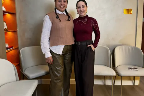 Sala de espera da Maélia com poltronas claras e estante iluminada