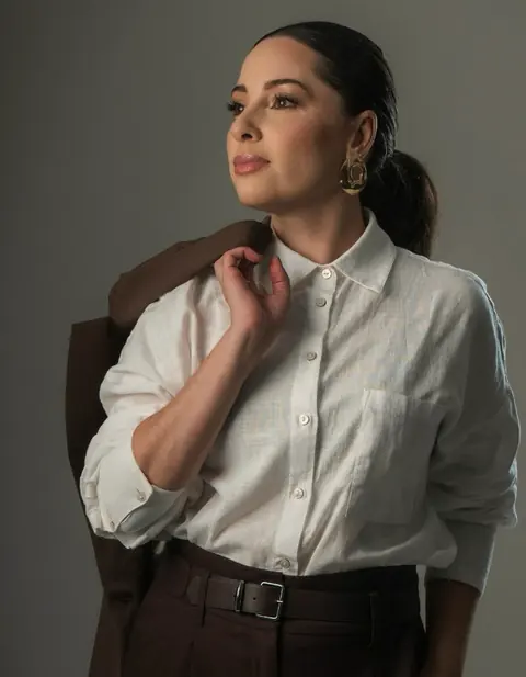 Mariana Pacheco de camisa branca, olhando para o lado