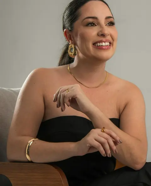 Mariana Pacheco sorrindo, sentada numa poltrona